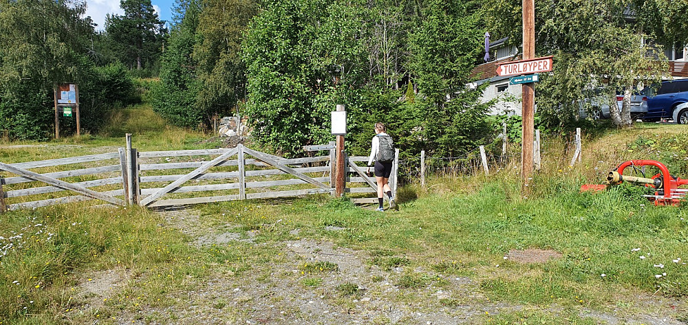 Skilt og grind der turen startet. Etter litt diskusjon lot vi syklene stå, og satset på en rundtur til fots