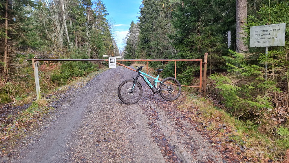 Jeg parkerte ved en oppstillingsplass for redskap og brask, og syklet videre innover til bommen.