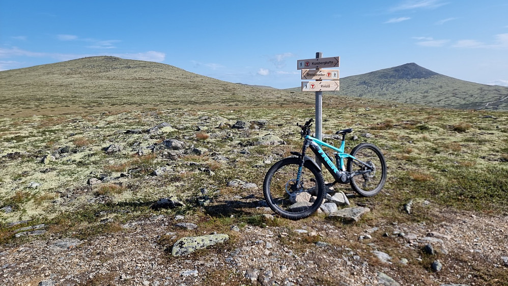 Stikryss med skilt oppe på fjellet. Kampen til venstre i bakgrunnen
