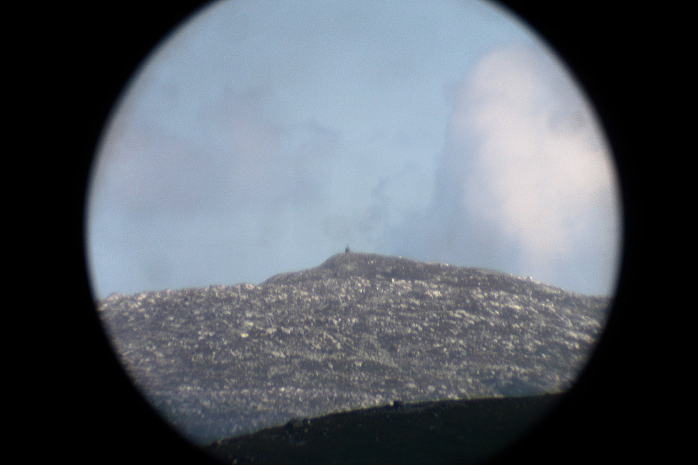 Bildet Fredrik tok gjennom en kikkert fra hytten sin av meg og Øyvind som står på varden på toppen av Gråfjell.