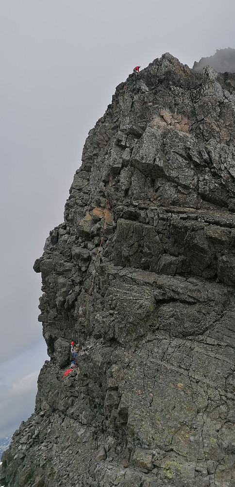 Dette er en mindre god løsning. Sikt inn på den "brune" flata midt i fjellet og følg løssteinene horisontalt vekk fra fotografen. Da er det et steg ut og rett opp, fremfor en full 50 m lengde i superløst fjell. Da slipper man unna mye steinsprang og det blir ikke kø slik som i dag!!!