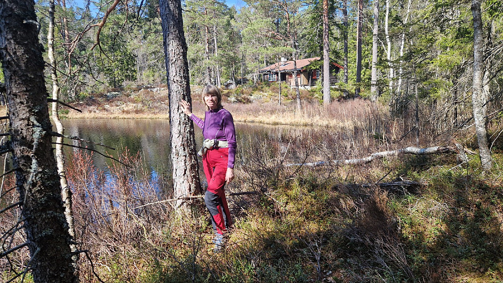 Ann Kristin ved Skotjern. Det går bilvei inn til hytta, men ikke mulig å se fra stien vår.