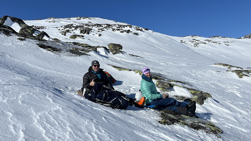 Kjetil og Linda i le for vinden under en rast på vei mot Rasletinden