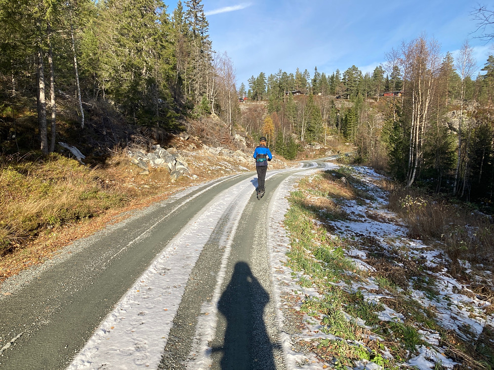 Susanne på ståmopeden oppover grusveien.