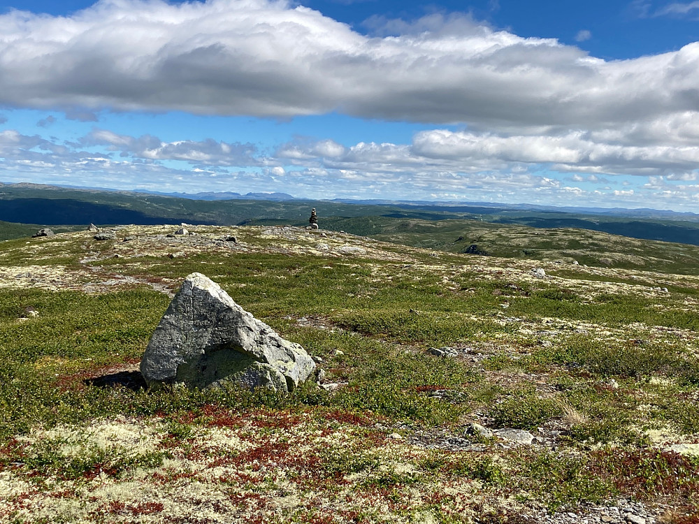 Her sitter jeg i le av den lille varden på Vedalshøgde og ser nedover mot den store varden og østover til det jeg tror er Fauskofjell.