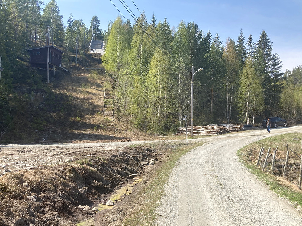 Hoppbakke til venstre i bildet. Bilen parkert i skyggen til høyre.