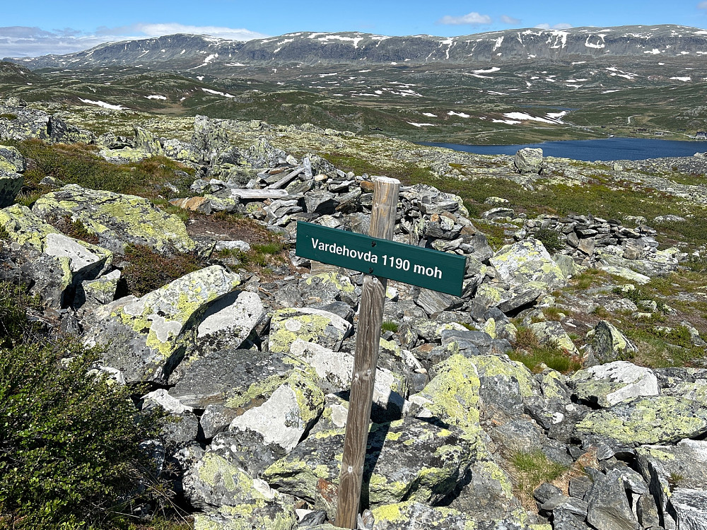 Må ha vært ei hytte her oppe, rett bak skiltet. I bakgrunnen troner Reineskarvet.