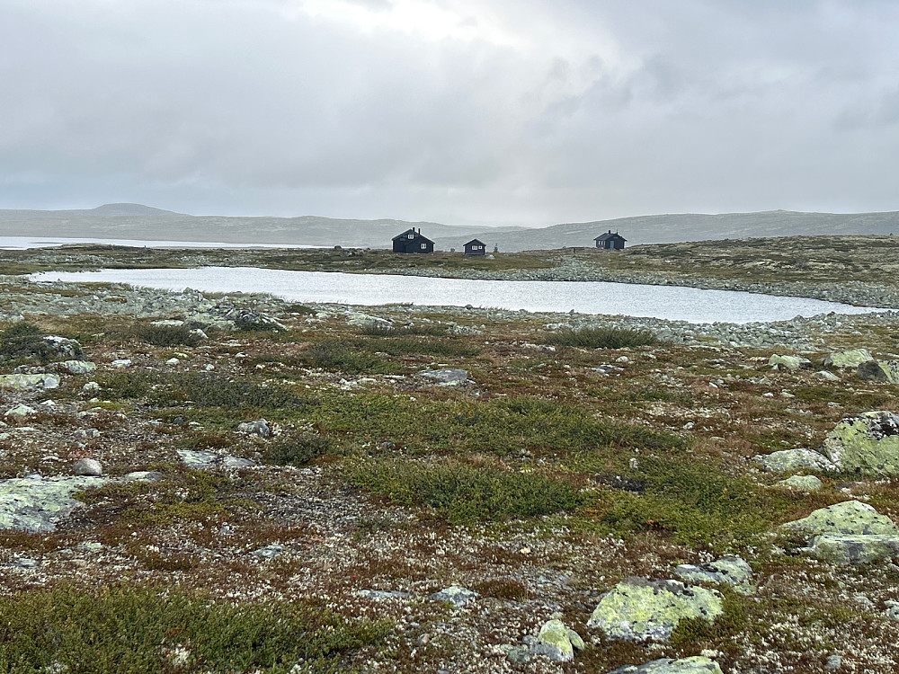 Lågaros turisthytte bak drikkevannet for hytta med Bjornesfjorden og fjelltoppen Nottaren i bakgrunnen til venstre.
