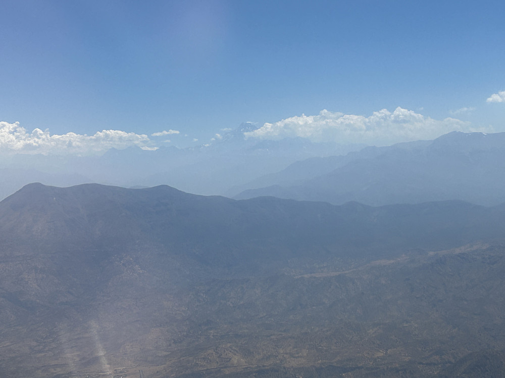 Litt før landing i Santiago ses det et høyt fjell i nordøst. Det er midt i dette bildet, med toppen så vidt over skydekket. Kan det være sørvestsiden av Aconcagua?