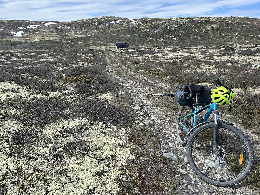 Sykkelen min med oppakning ved Ulvelihytta med Høljabrotet i bakgrunnen.