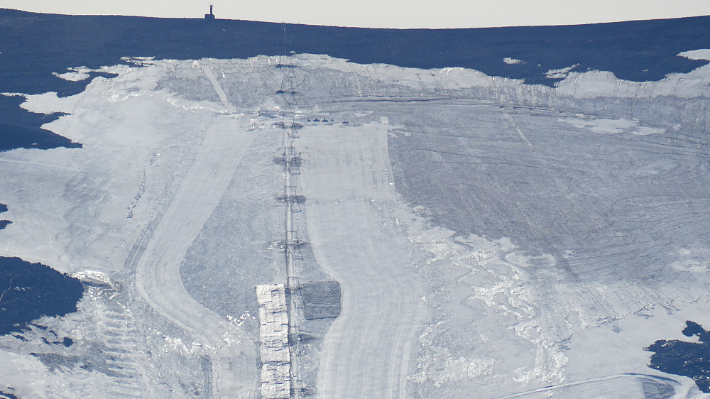 Sterkt zoomet bilde fra skianlegget på Juvasshytta. De jobber for å bevare snøen lengst mulig ved å lagre snø og bruke presenning.Breen minker voldsomt for hvert år.