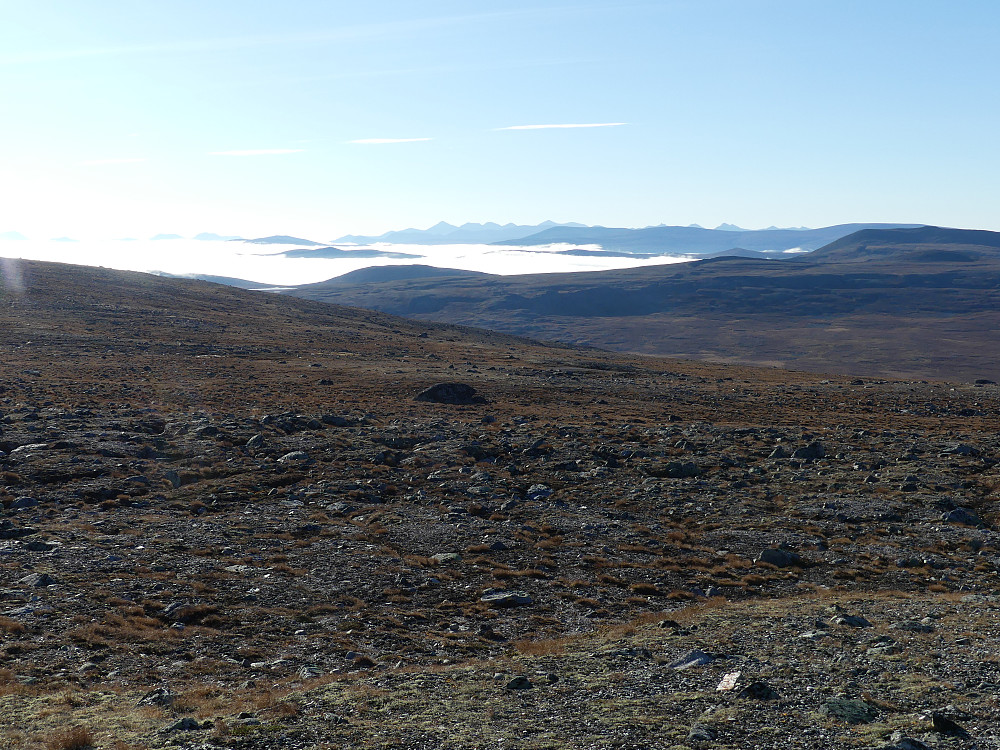 Tåka ligger tjukk over Hjerkinn. Rondane stikker opp i bakgrunnen.