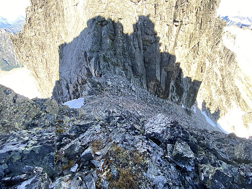 Image #22: Looking down into the notch separating Mount Vestre Trolltind from Mount Store Trolltind. Note how one steep chute on each side meet to form this large notch on the edge of this mountain range.