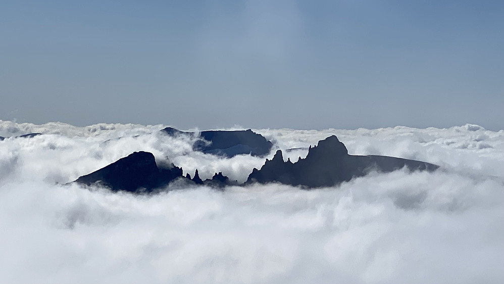Bilde #14: Utsikt fra Store Trolltind mot Trolltindan i Rauma, dvs. mot pinnaklene og toppene som flankerer Trollveggen. Fra venstre sees Trollryggen [1725 m.o.h.], Trollspiret [1670], Trollgubben [1631], Trollkjerringa [1646], Brurjentene [1620], Brudgommen [1728] og Store Trolltind [1788 m.o.h.]. Bakom Trolltindan sees Finnan [1786 m.o.h.].