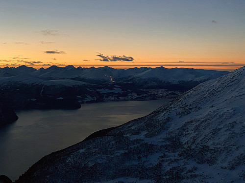 Bilde #10: Utsikt fra Hunden [943 m.o.h.] utover Norddalsfjorden. Lysrekka omtrent midt på bildet er lyskasterne langs slalomløypa på Furset-sida på Strandafjellet.