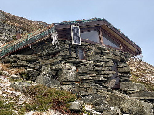 Bilde #5: Like nedenfor toppen av Goaldet, har Lepsøy Idrettslag, sammen med andre frivillige bygget ei hytte, hvor man kan søke ly for vær og vind. Hytta har vedovn for oppvarming, og et aldri så lite solcelle-anlegg for innvendig belysning.