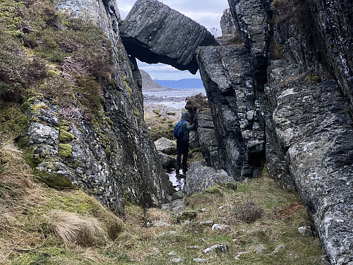 Bilde #14: En artig stein tvers over ei kløft og fjære-stien mellom Hellevika og Rønstad passerer gjennom kløfta og under steinen.