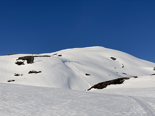 Bilde #5: I skaret mellom Hunden [943 m.o.h.] og Klovfjellet [980 m.o.h.]. Ruta videre herfra går til høyre over toppen på Klovfjellet, så ned i ei lita grop, og deretter oppover sørsida av Berdalsnibba litt til høyre for midten av bildet. Omtrent midt i bildet sees forøvrig en kant etter snøskred fra tidligere i vinter.