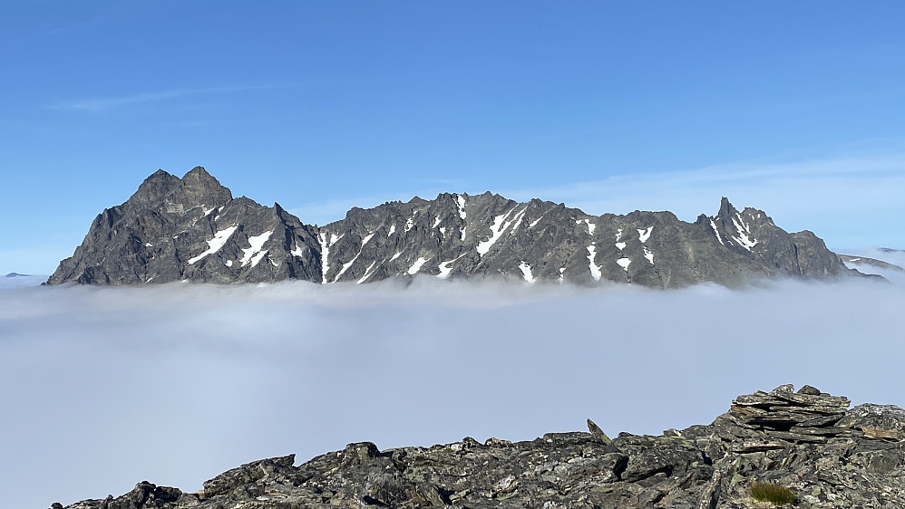 Bilde #17: Venjetindane med Venjetindtraversen så nesten ut som ei skute på havet der den "lå og fløt" i skydekket. Store [1852 m.o.h.] og Lille [1822 m.o.h.] Venjetind er de to toppene lengst ute til venstre. Kvanndalstinden [1744 m.o.h.] sees bak Venjetindtraversen langt ute til høyre.