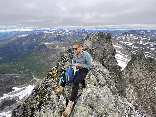 Bilde #19: På toppen av Kvanndalstinden [1744 m.o.h.], med Kvanndalen og Middagsfjellet [1159 m.o.h.] i bakgrunnen. Knausen som sees bak Dag, like til høyre for midten av bildet, er toppen vi kom opp på, og som vi måtte klyve ned fra, for å komme oss opp på hovedtoppen.
