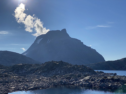 Bilde #3: På vei mot Kalskråtinden, som sees i kraftig motlys så tidlig på morgenen. Bildet er tatt fra bredden av Olaskarsvatnet.