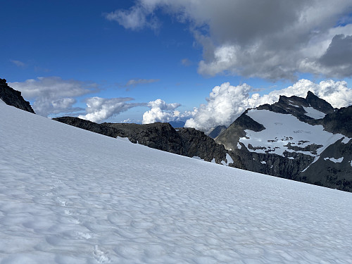 Bilde #14: Tilbakeblikk over breen, med mine egne spor til venstre i bildet. Jeg hadde med meg grove Snowline-kramper som jeg benyttet under krysningen av breen. Breen bratner grådig til nedover mot nord, så hvis man først begynner å gli nedover, så er det ingen ting som stopper en. Venjetindane til høyre i bildet.