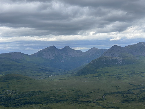 Bilde #7: Utsikt nordøstover. I bakerste rekke sees Middagsfjellet [902 m.o.h.], Trolltinden [1170 m.o.h.], Ytstetinden [1162 m.o.h.] og Remmemstinden [1090 m.o.h.]; og til høyre i bildet sees Varguraksla [772 m.o.h.], Sandtinden [1068 m.o.h.] og Sprovstinden [1194 m.o.h.]. Dalen mellom de to fjellkjedene er Skorgedalen.
