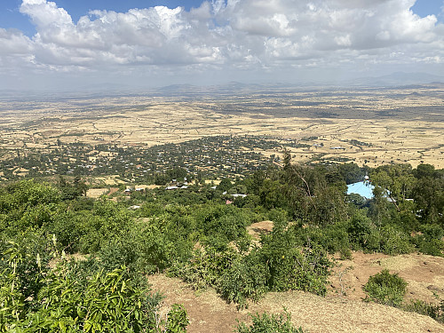 Image #5: A view of Onebirr village, with the roof of the Wenber Maryam Church visible in the forest.