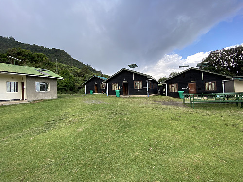 Image #11: At Miriakamba. The three dark brown wooden huts are for guests/tourists, and the concrete building to the left is the accommodation for the rangers.