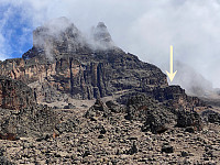 Mawenzi in slightly cloudy weather. The plateau at which the arrow points, is the Mawenzi Midpoint. Hans Meyer Peak might be glimpsed up in the clouds.