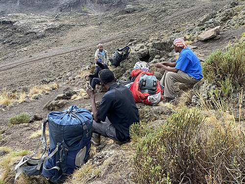 Image #24: Having a rest at the "internet point". The Mawenzi Tarn Hut is located just behind the mountain knoll in the upper left corner of the picture.