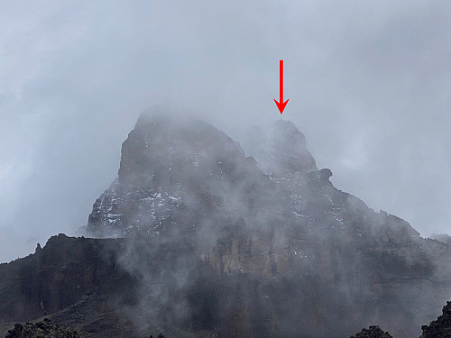 Image #27: Mawenzi becomes visible through the clouds. The red arrow indicates the summit (i.e. the Hans Meyer Peak).
