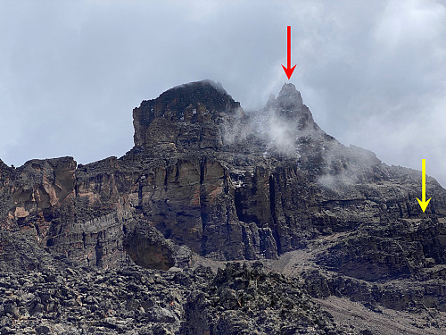 Image 28: Mawenzi with three of its peaks visible through the clouds. The red arrow marks the summit, and the yellow arrow marks the "Midpoint".