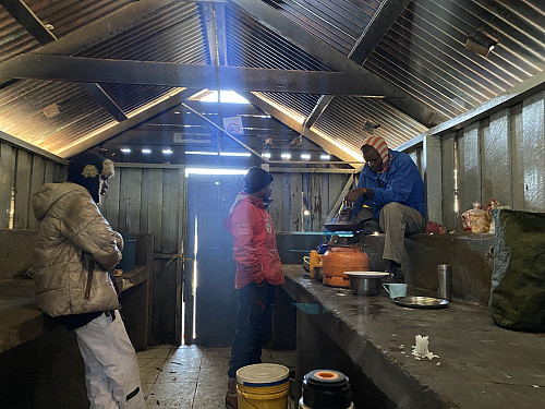 Image #64: The Doctor of the Kitchen preparing the breakfast. It's rather cold in the morning at the Kibo Huts.