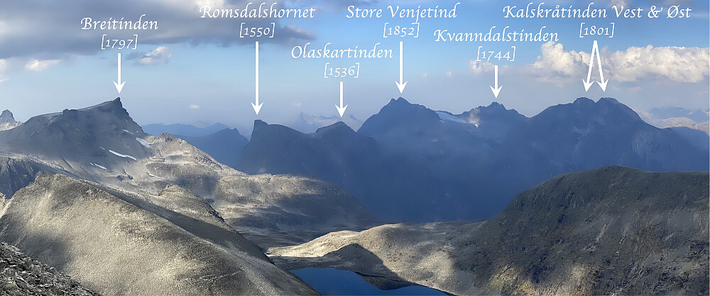 Bilde #17: Utsikt mot nordøst fra Skarfjellet 1723. I tillegg til toppene som er navngitt på bildet, sees Trollryggen [1725 m.o.h.] helt ute i venstre billedkant; like til venstre for Romsdalshornet sees Blånebba [1320 m.o.h.] på Romsdalseggen; og bak Olaskartinden sees Hesteskotraversen i det fjerne.