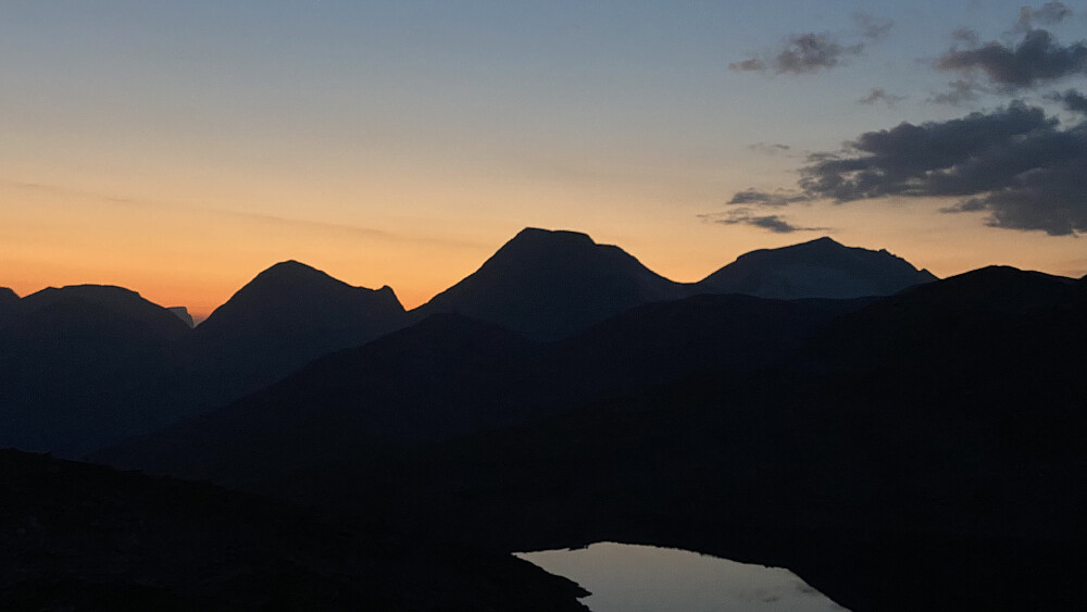 Bilde #21: På vei ned fra Kulehøgda [1516 m.o.h.]. Den mørke silhuettene omtrent midt i bildet er av Skarfjellenden, mens silhuetten i bakgrunnen er av Småholtinden, Alnestinden og Finnan.