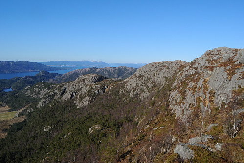 Den nordlige delen av fjellveggen synast. Med Juten og Tillandsfjella i bakgrunnen, og heilt ytterst skimtar me Sveio og Stord.