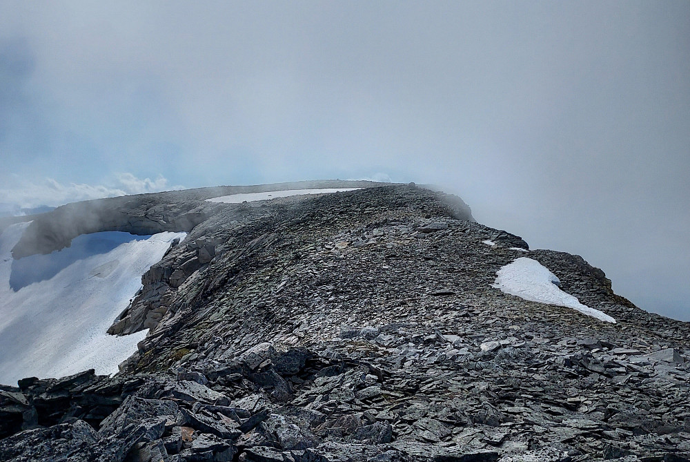 Omtrent midtveis på ryggen mellom Sandurfjellet og Storskredfjellet, med høyeste punkt rett forut. Skodde blåser opp fra Litlekupa i nord 