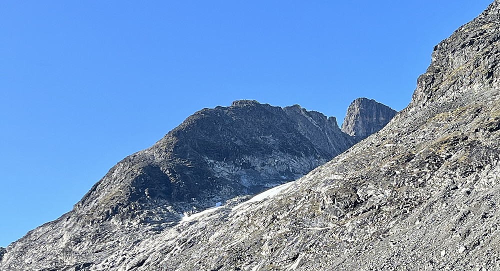 Hellstugupiggen kommer til syne i det man nærmer seg bretunga til Hellstugubreen. Bakenfor så reiser skuldra fra Nørdre Hellstugutinden seg