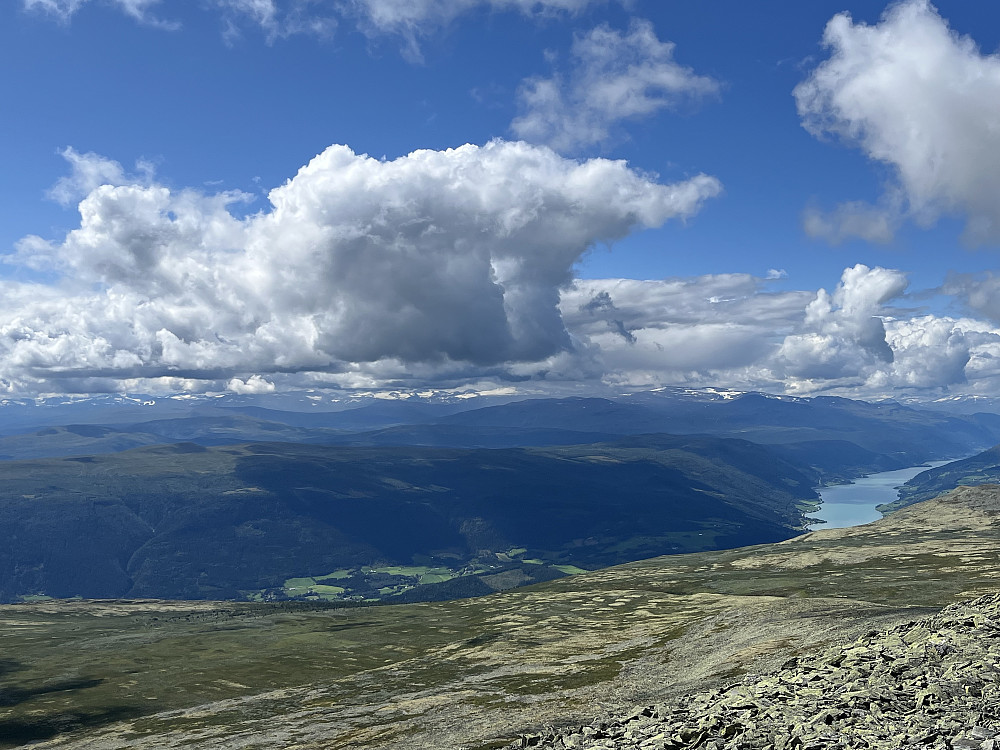 Utsikt til Norges tre høyest beliggende fjellområder: Jotunheimen delvis inkranset i skyer. Vågåvatnet ned til venstre