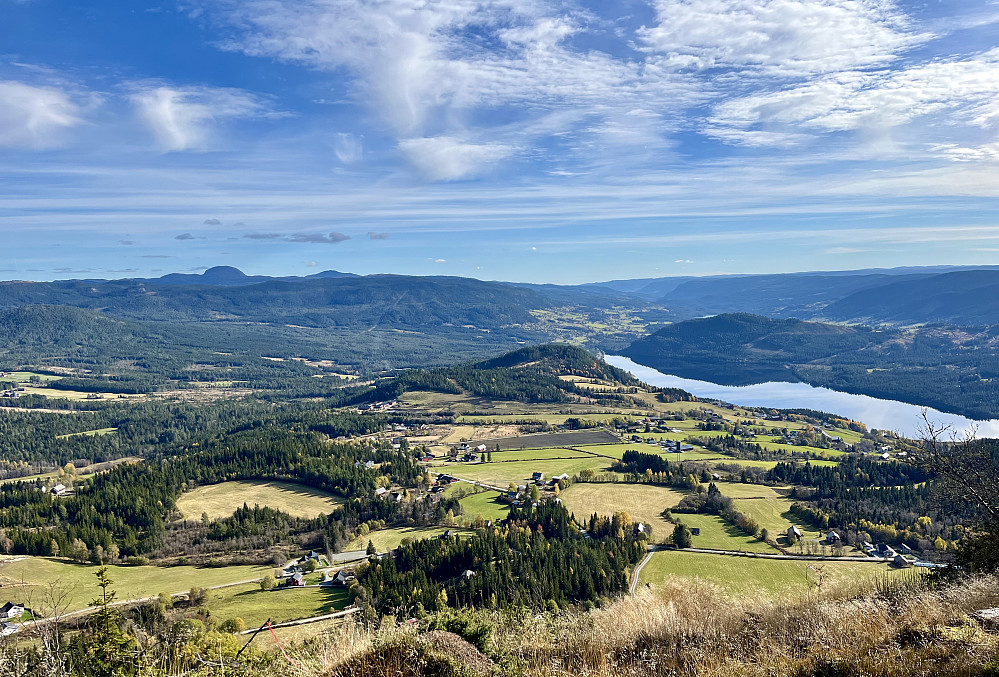 Fra toppen er det god utsikt mot det omliggende kulturlandskapet. Heggefjorden ligger blikkstille nede til høyre. I bakgrunnen stikker Rundemellen opp. 