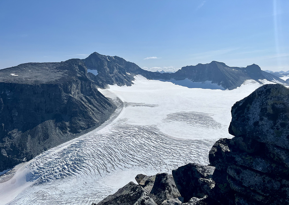 Voldsomme sprekker ned brefallet til Storjuvbreen. Galdhøpiggenmassivet ruver i bakgrunnen.