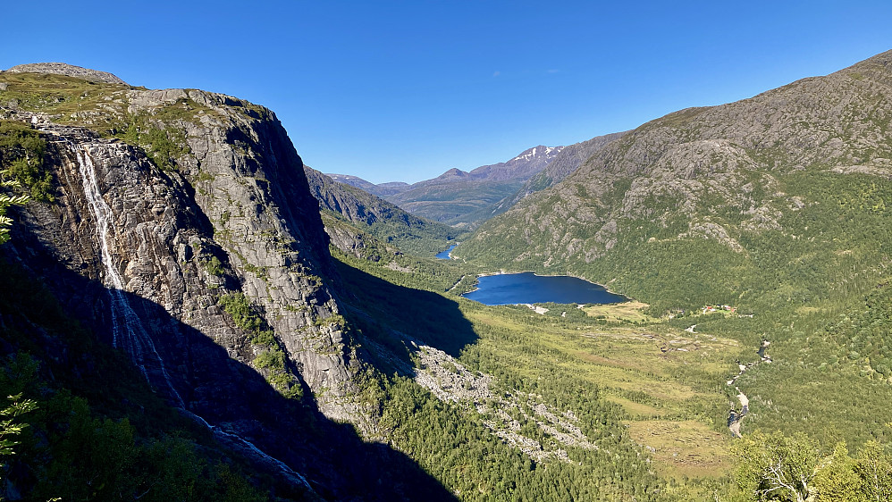 Utsikt mot Tosdalen og Tosdalsvatnet fra nord for Keilåtinden. Storfjellet med bekken som kaster seg utfor det flere hundre meter høye floget til venstre