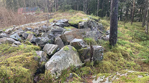 Kant bygget av grov stein langs gropen