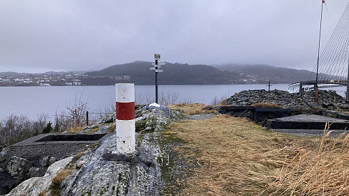 Søyle og rester av et annet fastmerke i bakgrunnen. Utsikt vestover mot Frekhaug