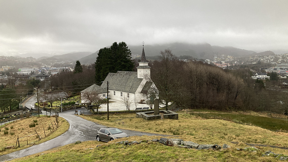 Åsane gamle kirke ble bygget før 1738. Kirken brant i 1795, ble gjenoppbygget men brant på nytt (påsatt) julaften 1992. Dagens kirke er fra 1995. Foran kirken står det en minnebautaen over falne fra Åsane under 2VK. Kirkegården er fra middelalderen