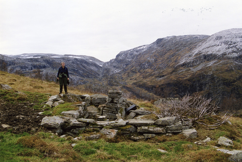 Astrid ved ruinene etter Frustøl Søre i Slondalen. I bakgrunnen Gommahaugane mot venstre og Mjølfjellet til høyre for Gommaskardet