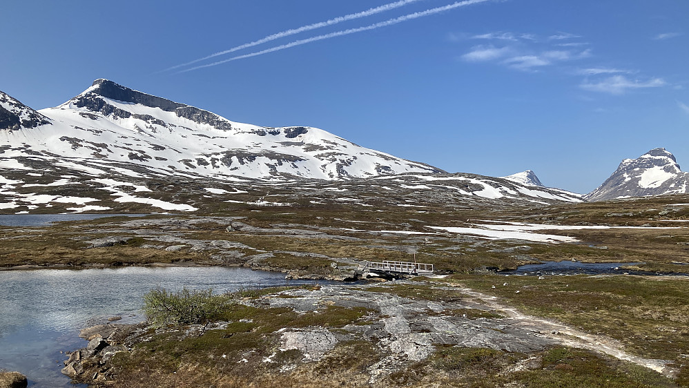 Broen over elven fra Skorrigorrivatnet. Lurfjelltinden mot venstre