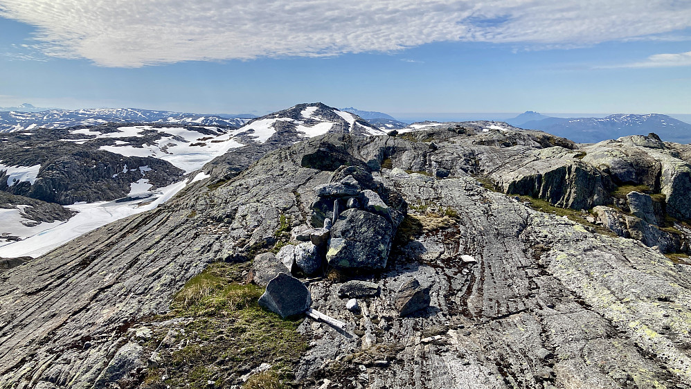 Liten varde med stang på Hallvardtinden. Nordtoven 995 i bakgrunnen mot vest