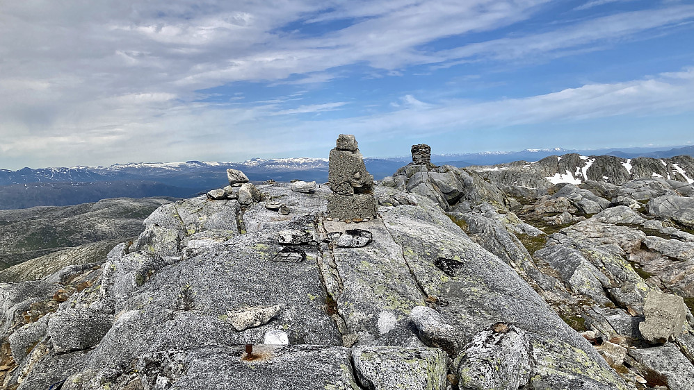 Bolter og trig-merke/støpt varde - høyest i Leirfjord. Steinvarden i bakgrunnen står ca. 50 m mot NØ og er i Hemnes kommune. Hallvardstinden i bakgrunnen mot høyre